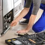 مركز صيانة كاريير 14 Male technician repairing refrigerator indoors